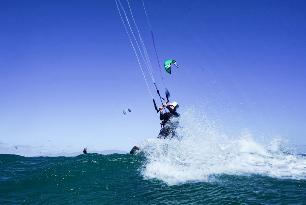 person kitesurfing on a wave